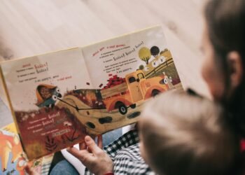 A mother and toddler sharing a story from an illustrated children's book indoors.